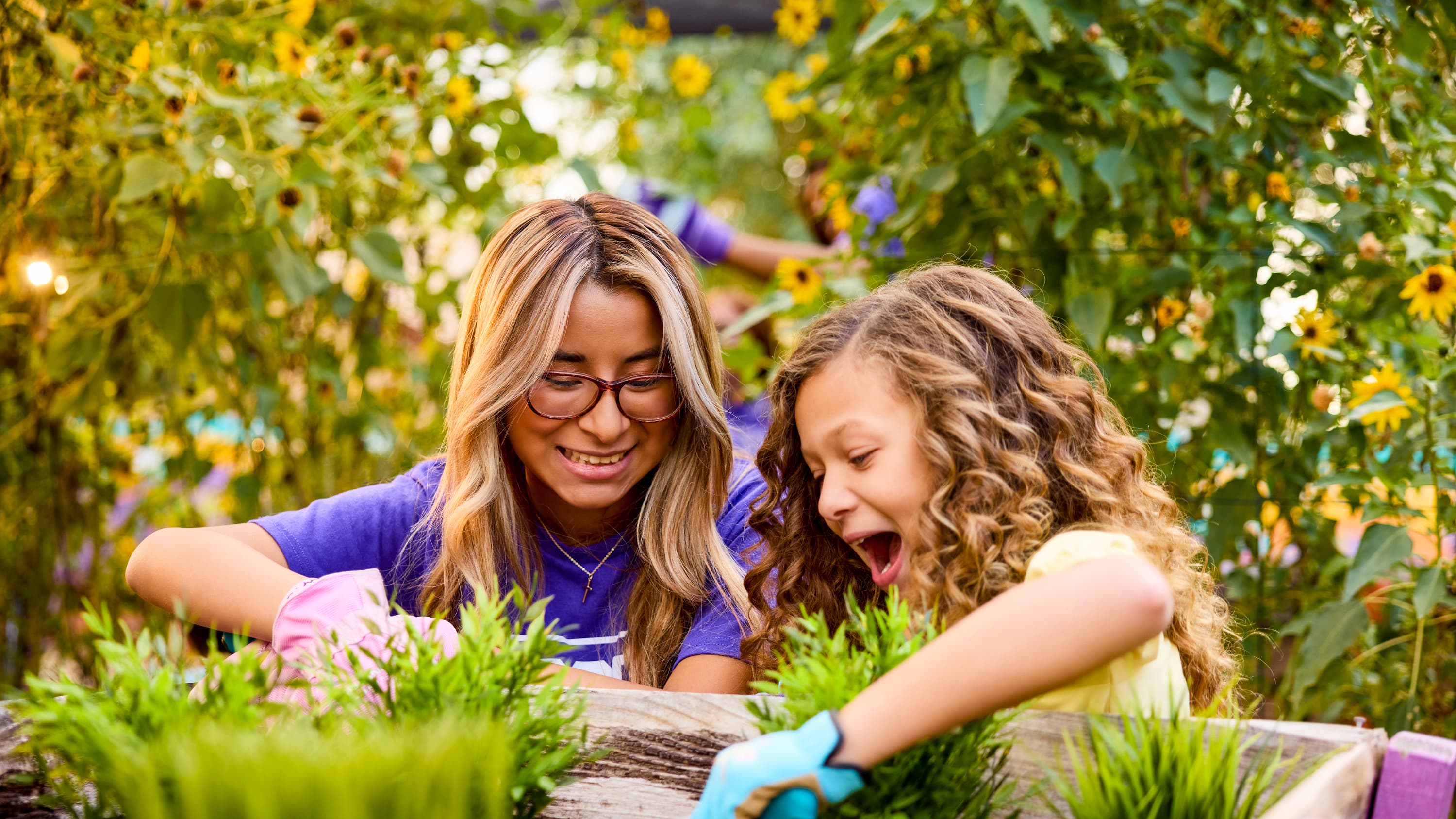 Female humanities and social science minor working in garden with young girl