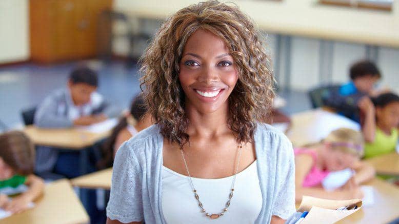 Teacher Stands in Front of Class Smiling