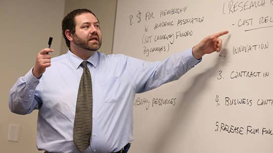 professor pointing at whiteboard