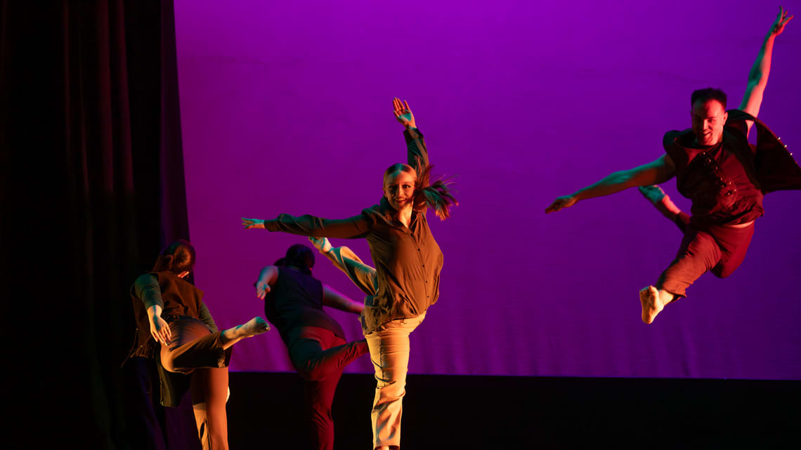 Group of dances in winter dance performance do a form of jete dance leap