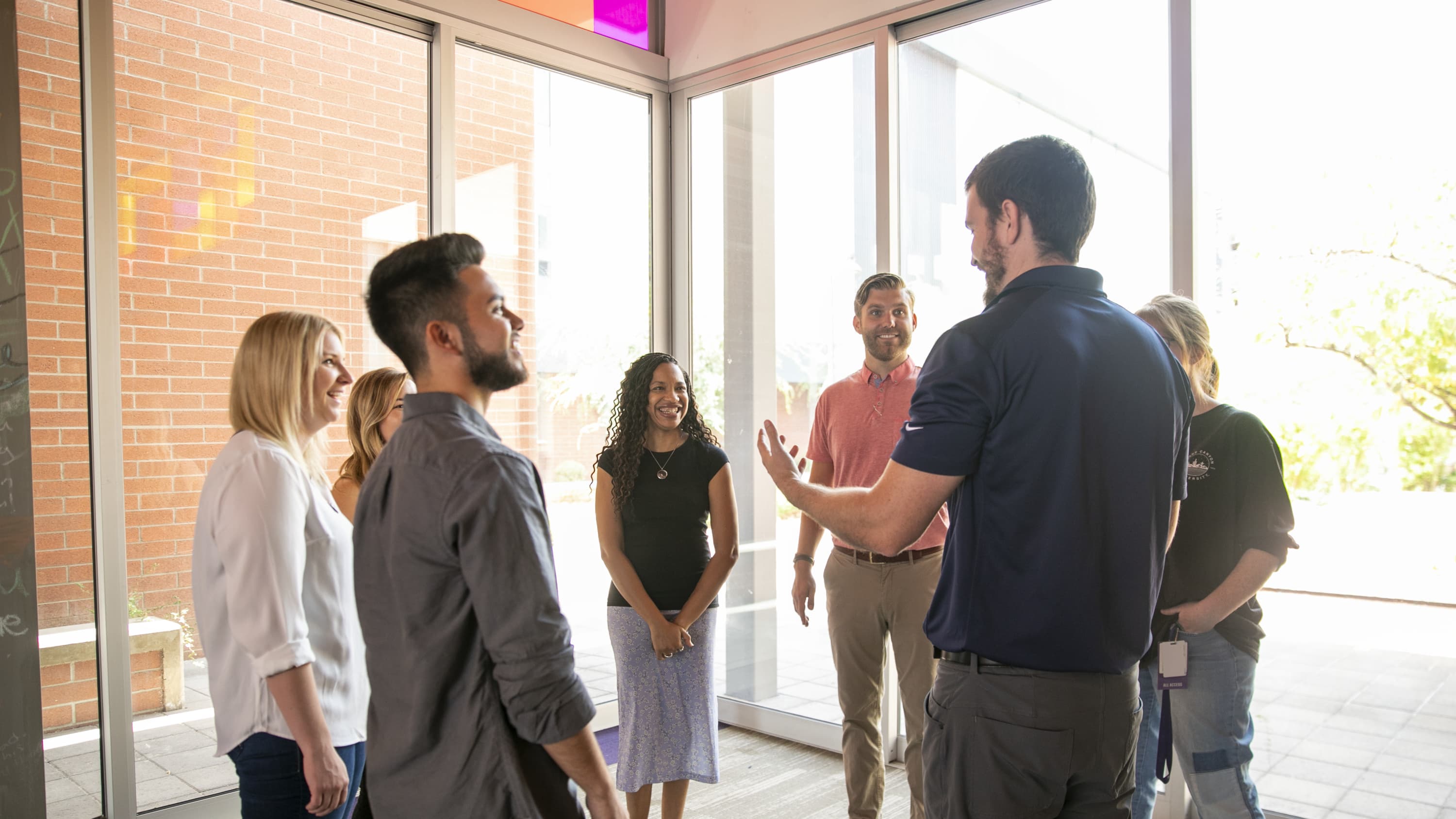 Group of male and female counseling degree students standing in discussion circle