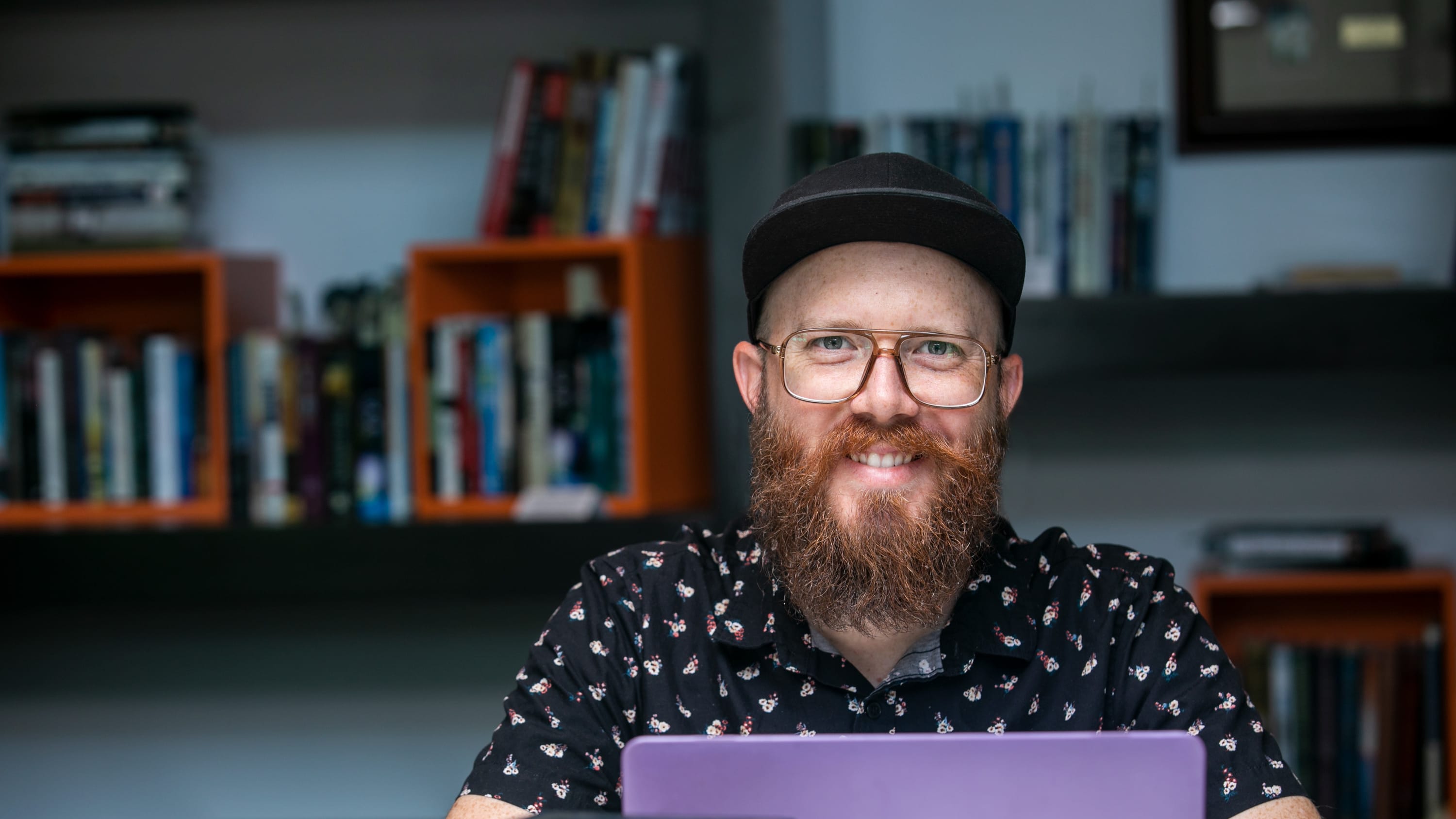 Male master's in legal studies major working on laptop in GCU library