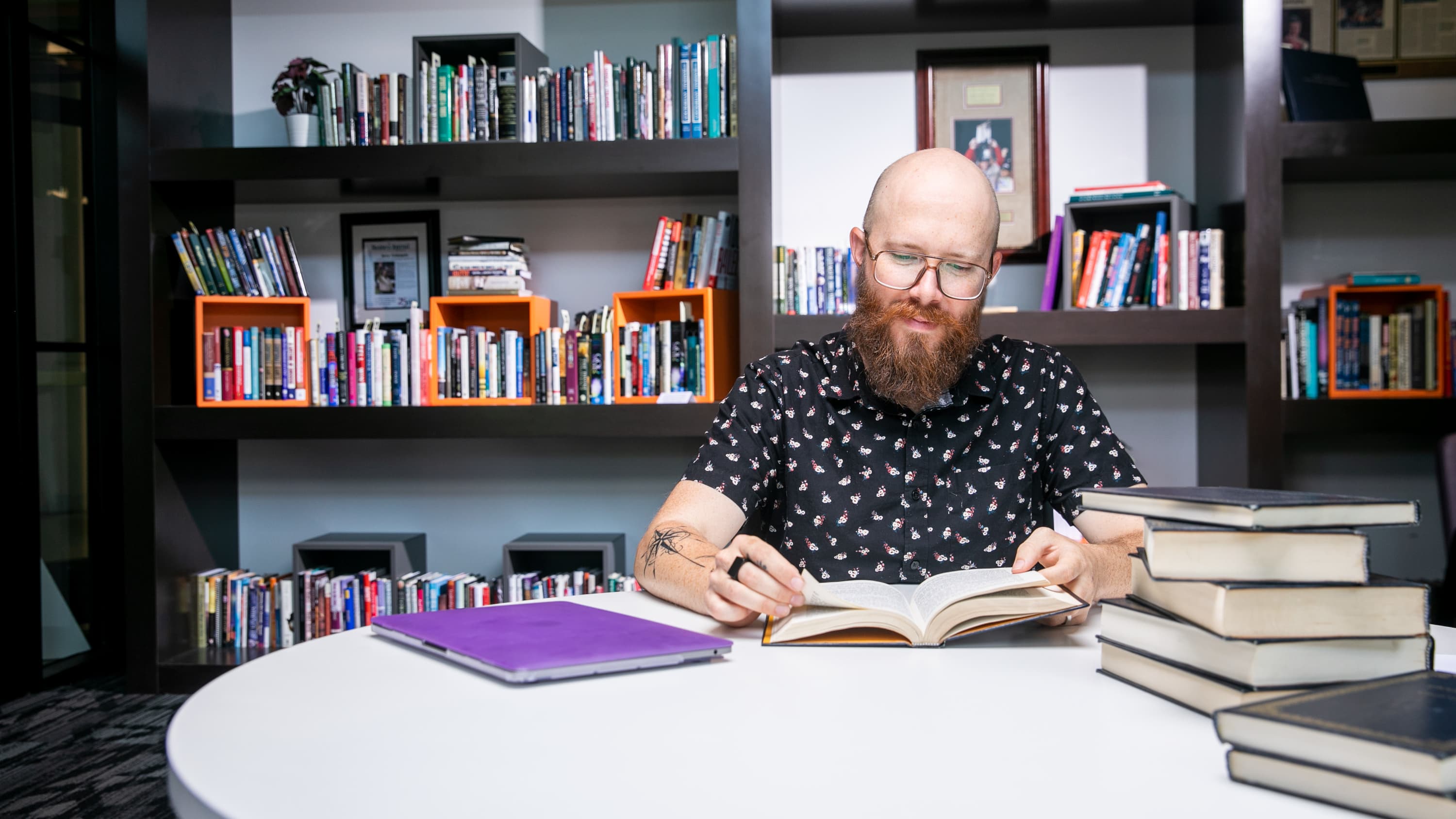 Man sitting at a table reading a book