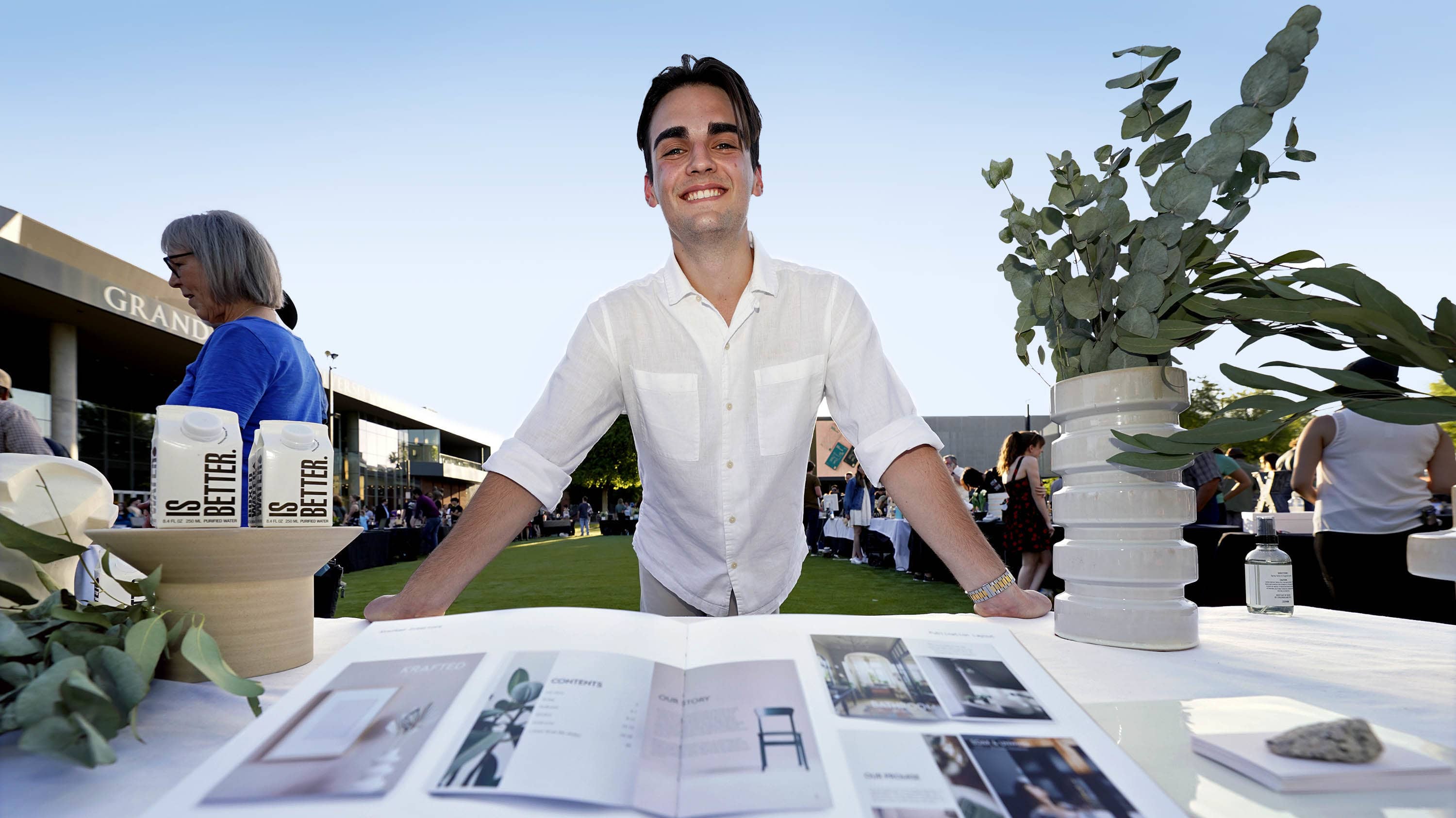 Male digital arts degree student smiling with portfolio at GCU