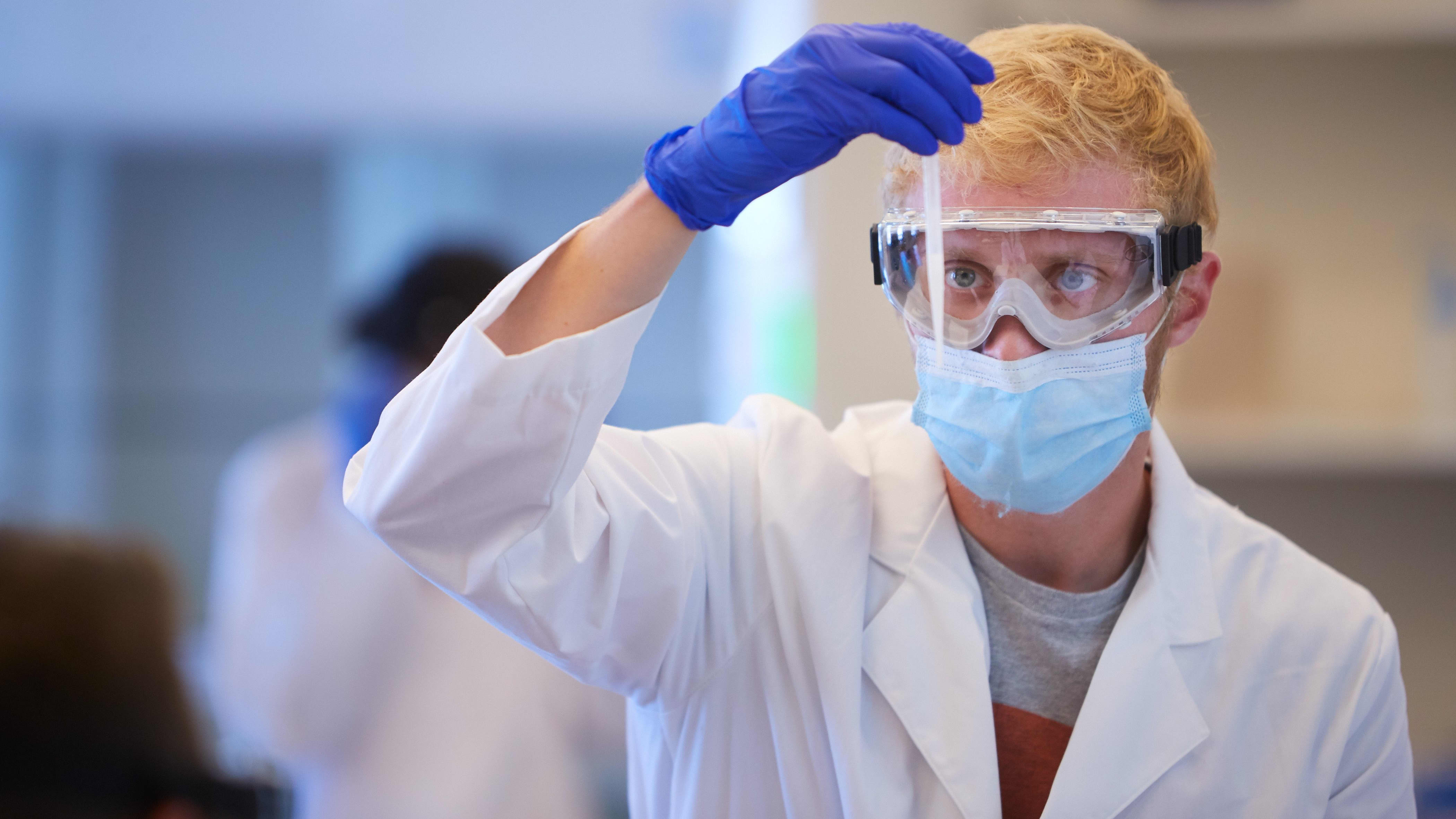 College of Natural Sciences student in white coat in a laboratory