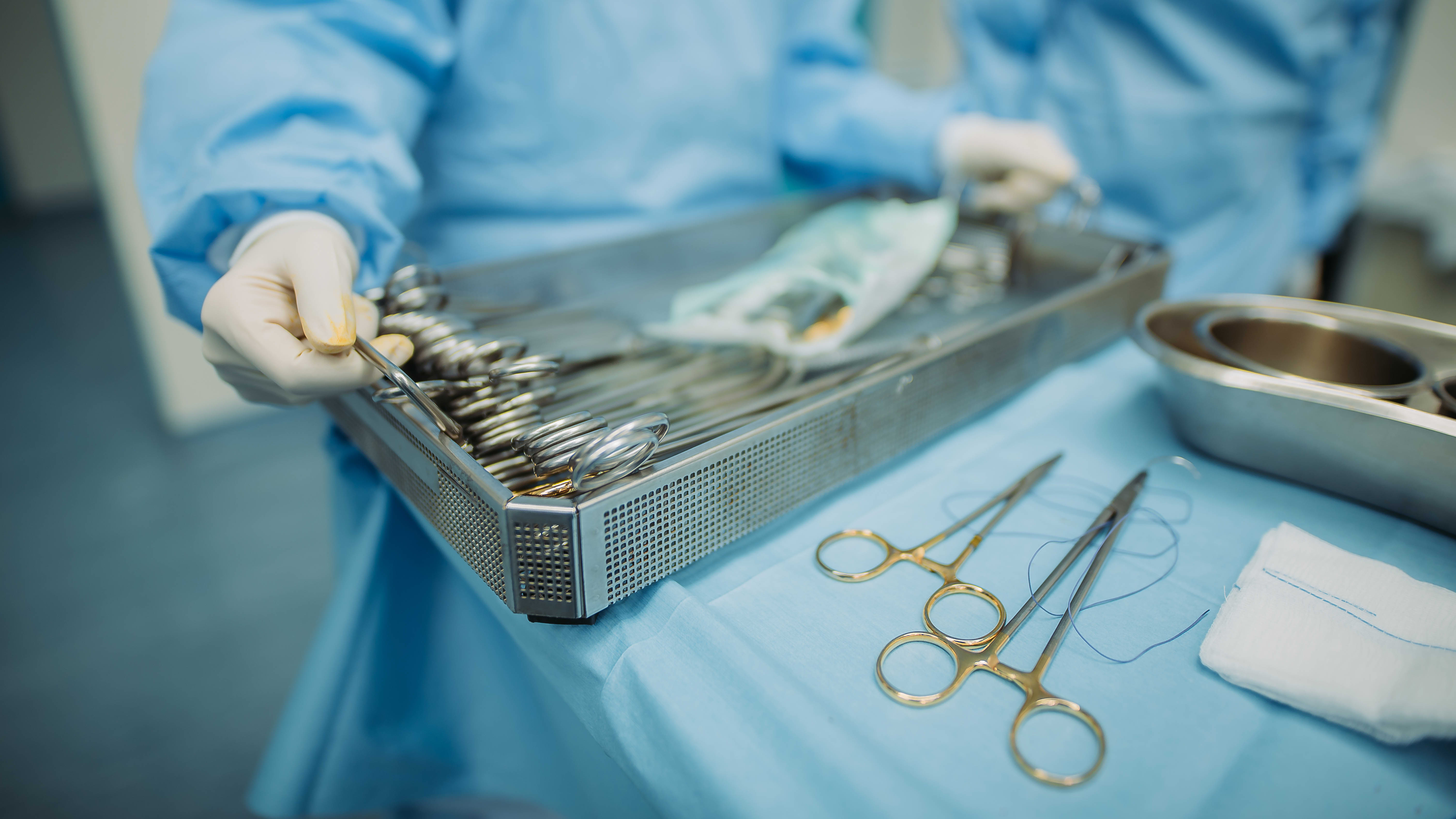 Autopsy Technician Hands Tray Full of Medical Utensils