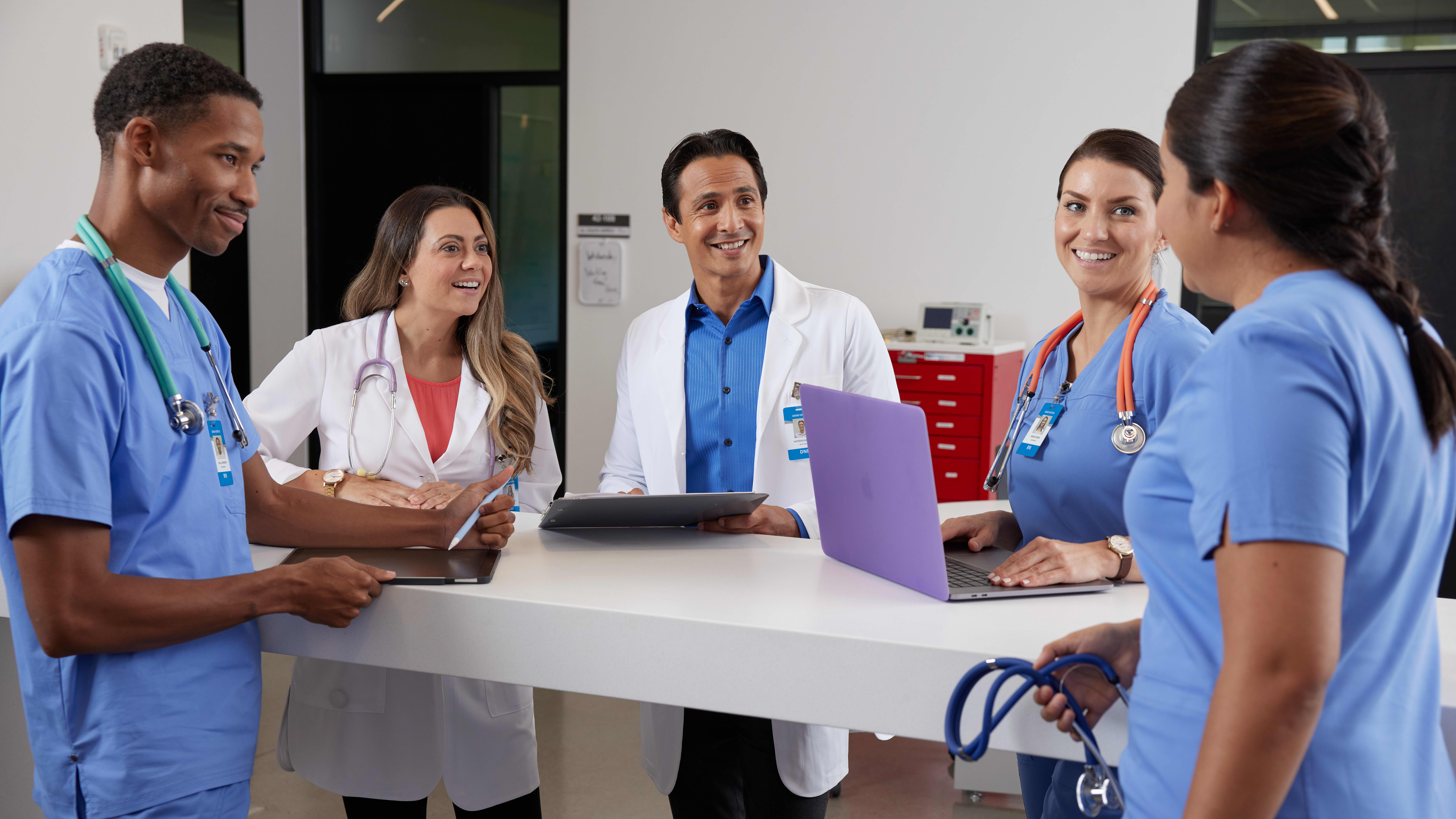 Graduate healthcare managers standing at a table