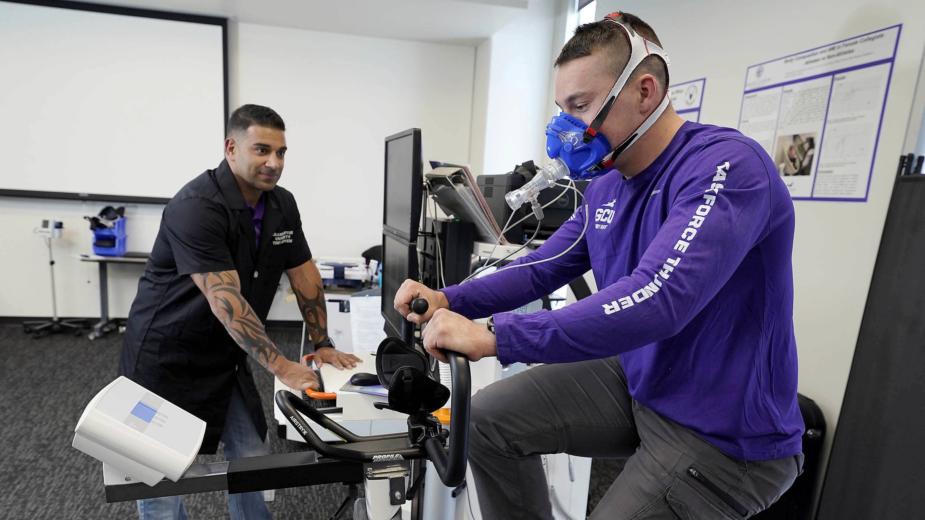 Male exercise science degree student working with instructor in classroom