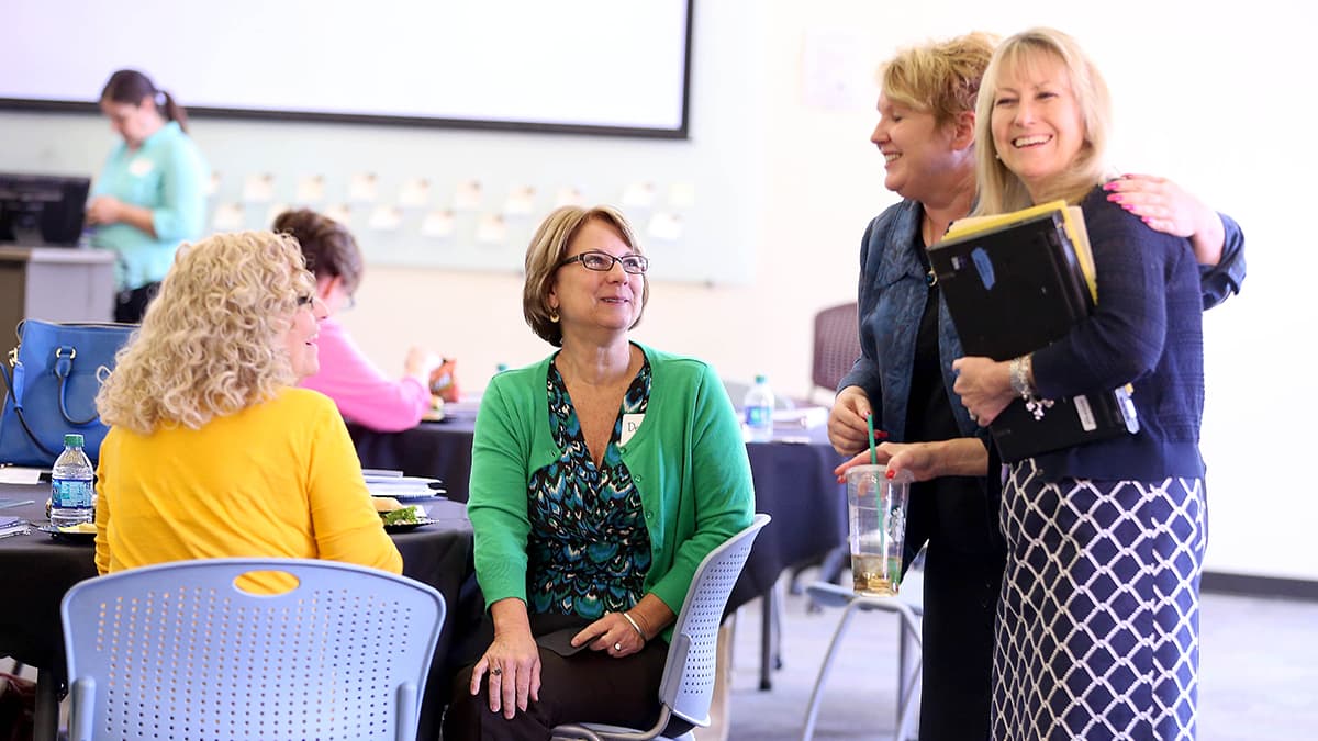 Four female teachers talking over a luncheon