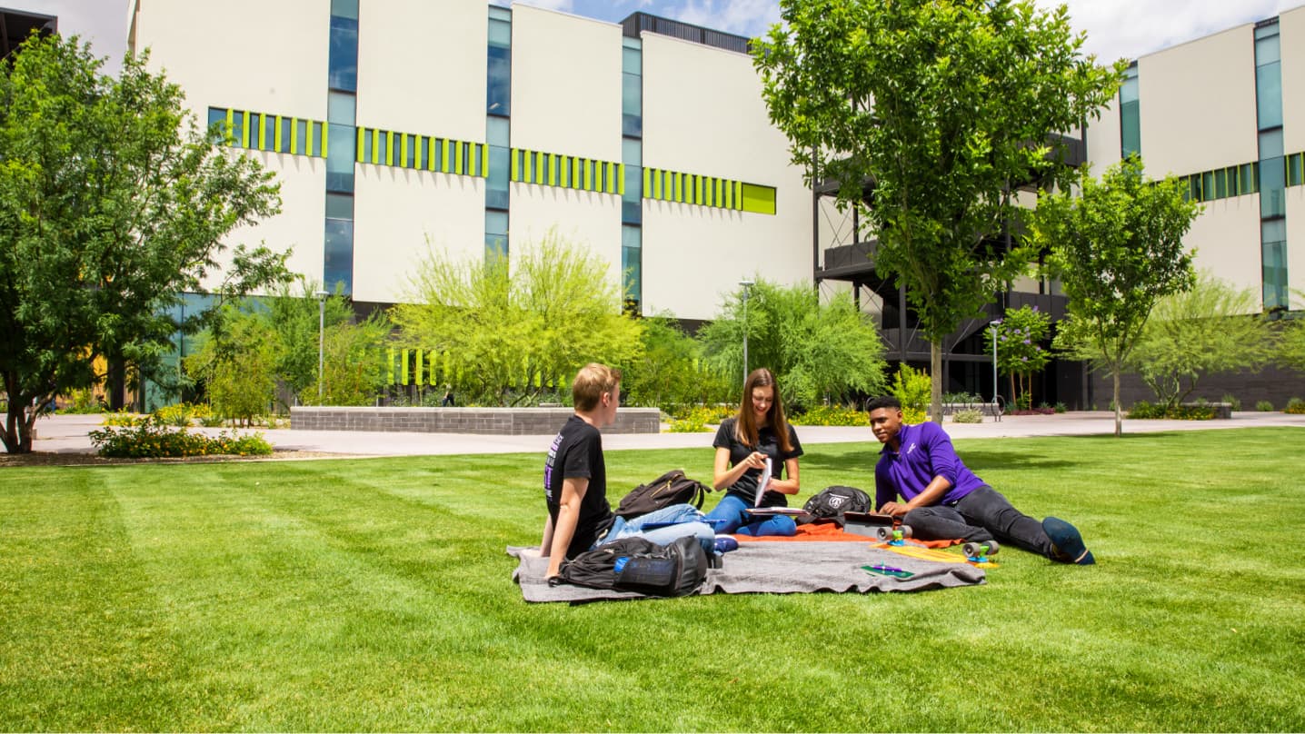 Students laying in grass on GCU campus