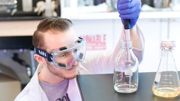 a student measures volume of liquids in beakers