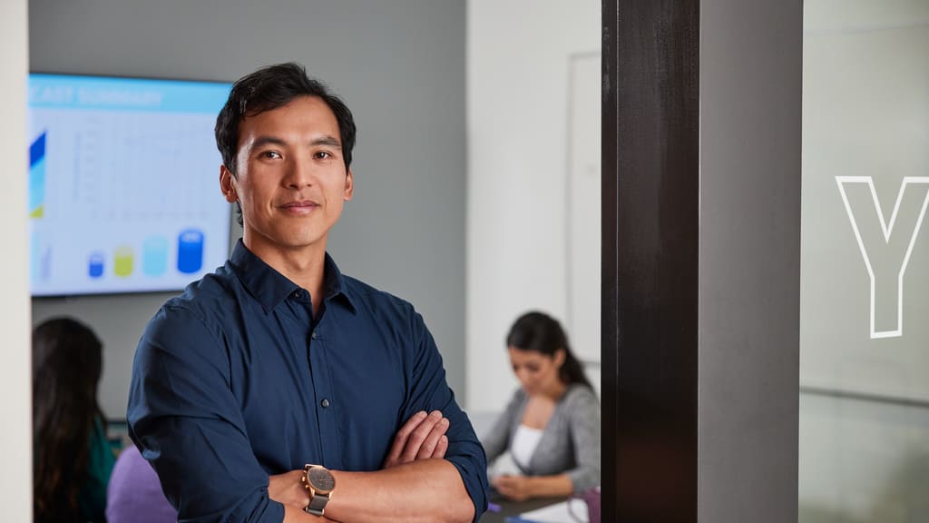 Colangelo College of Business student poses in front of a classroom at GCU