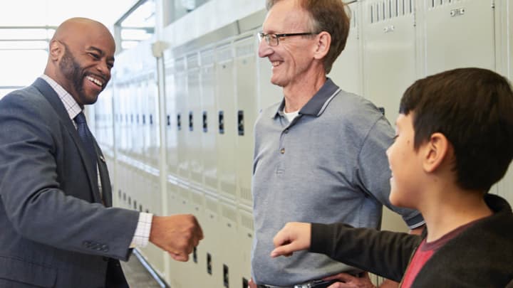 students meet together after class in a hallway