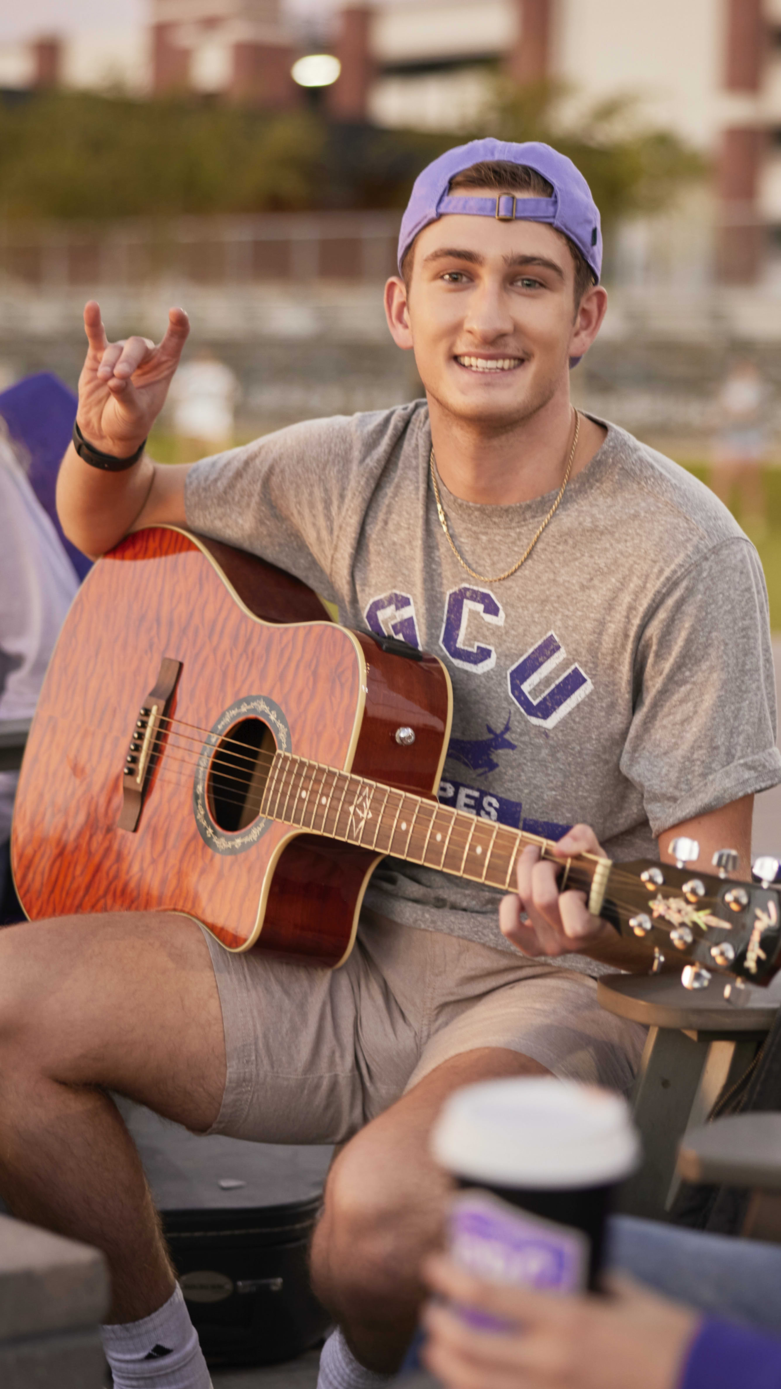 student with guitar throwing up lopes