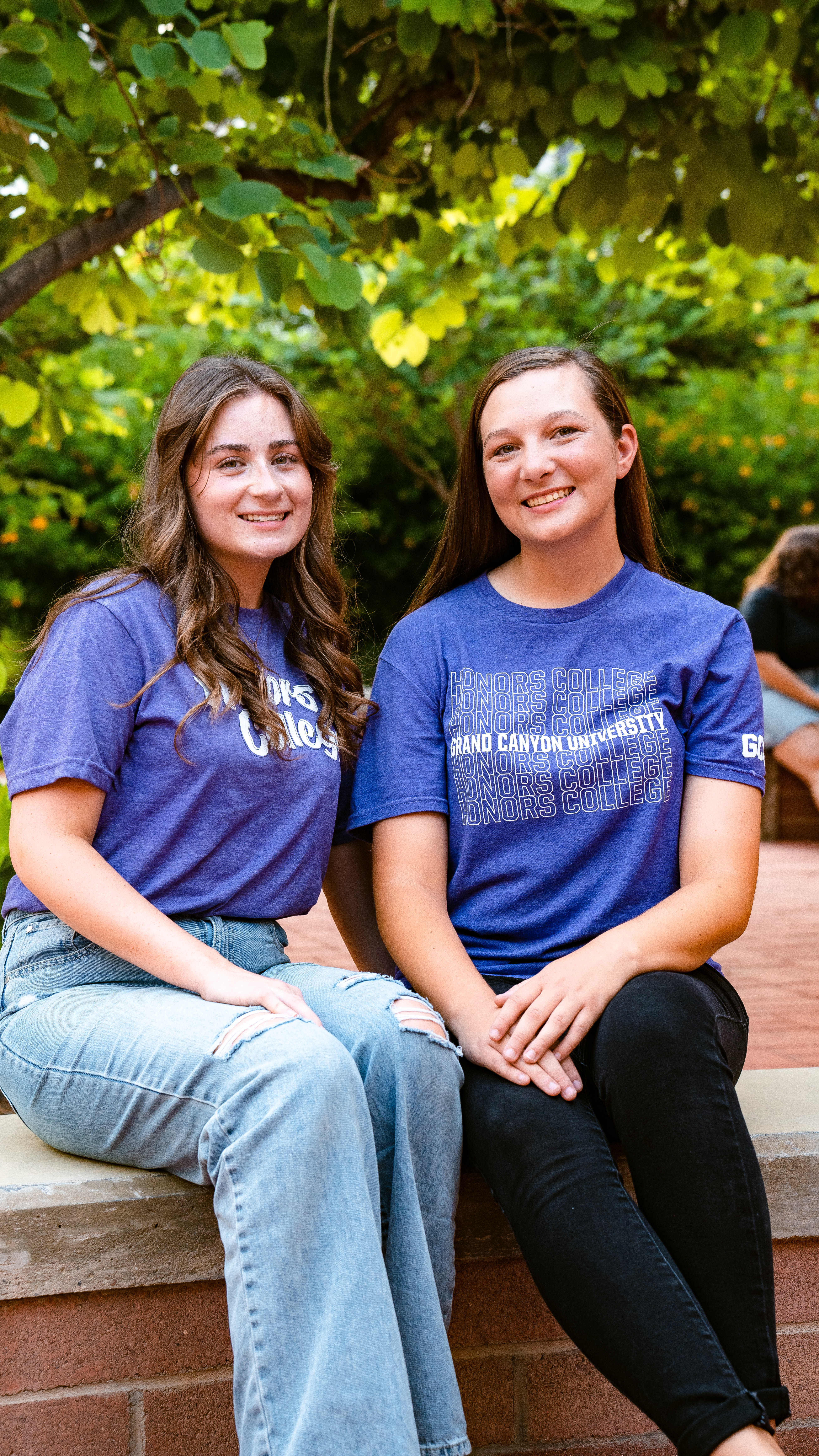 Two students smiling for camera on campus