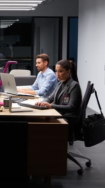 Computer Science students sitting at group table with computers