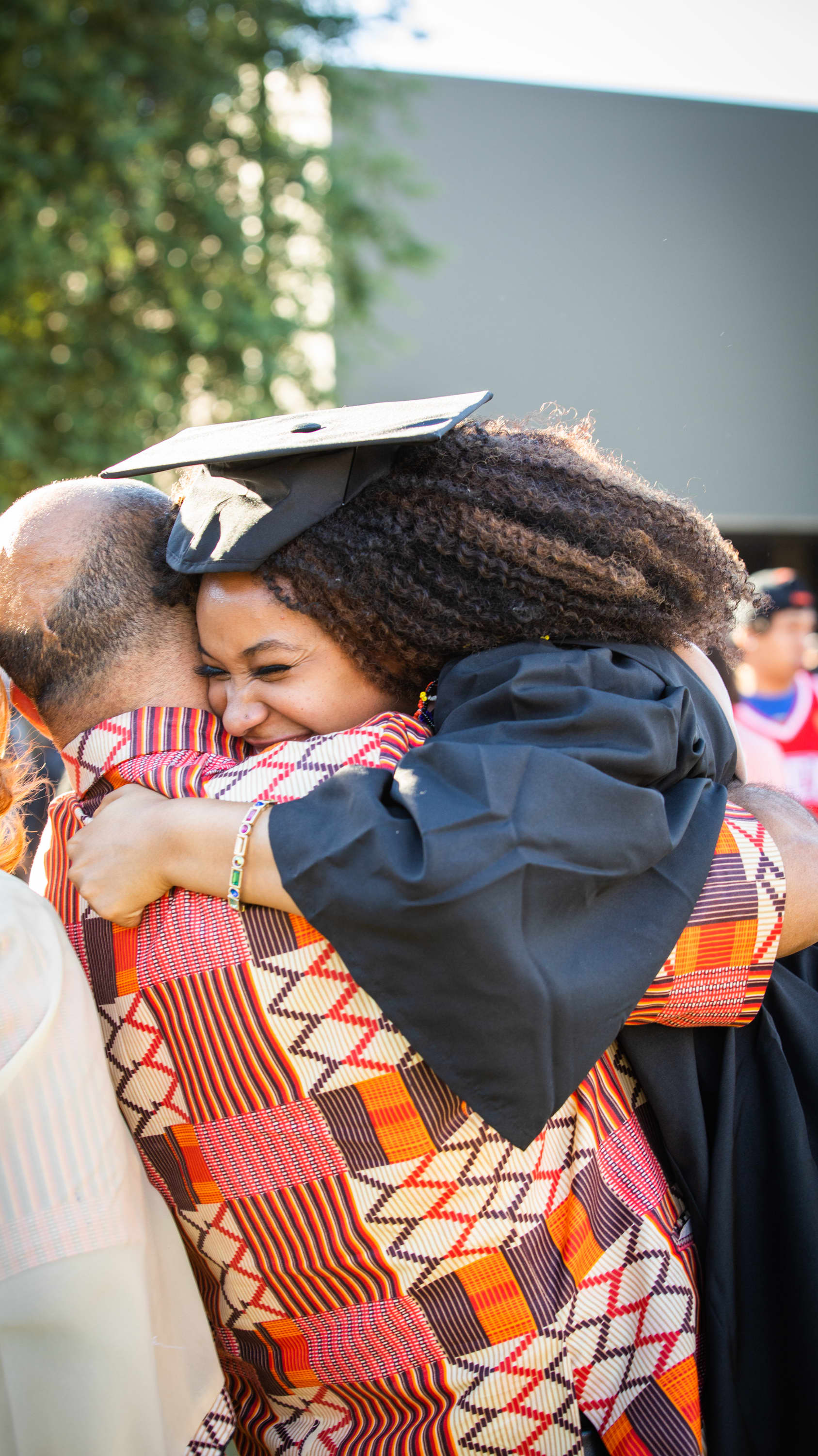 Female MBA degree graduate smiling and hugging dad at GCU commencement