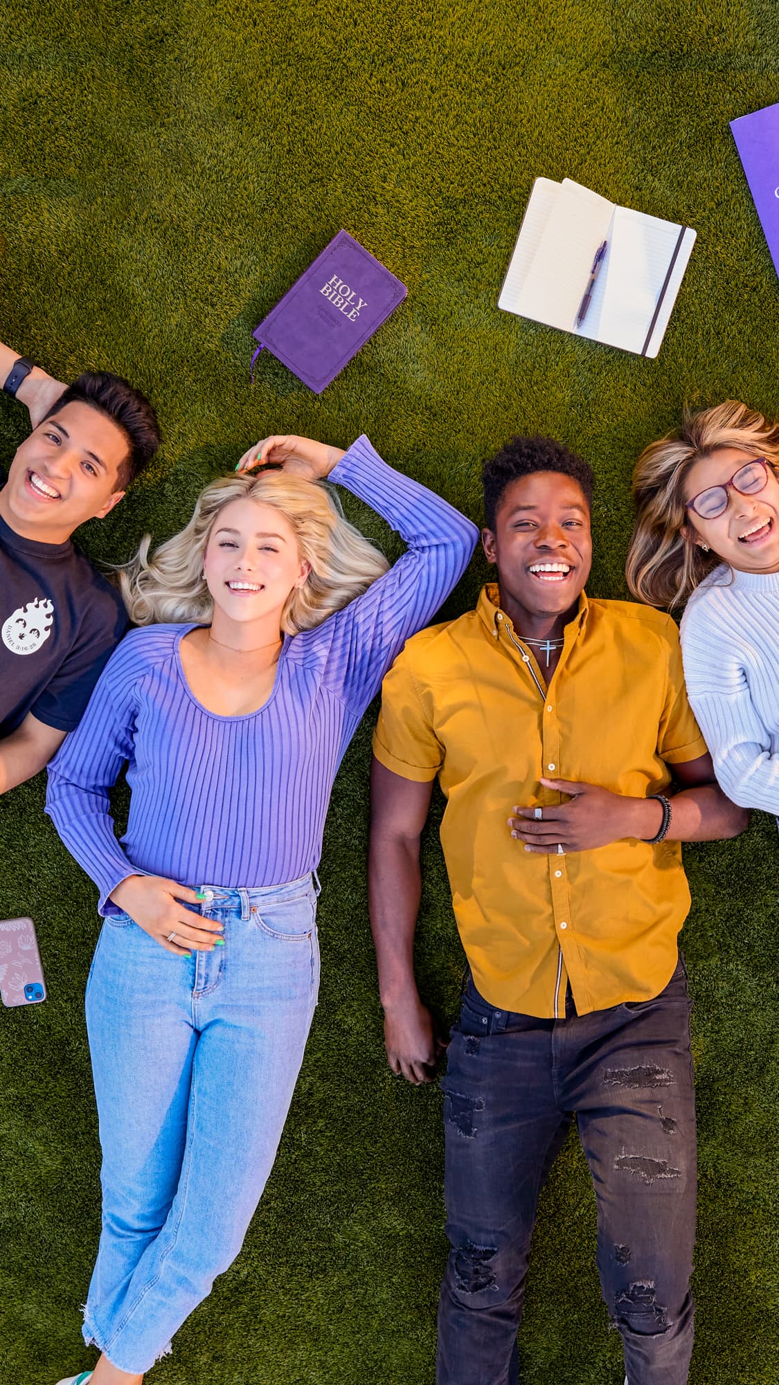 GCU students laying on the grass of a campus lawn