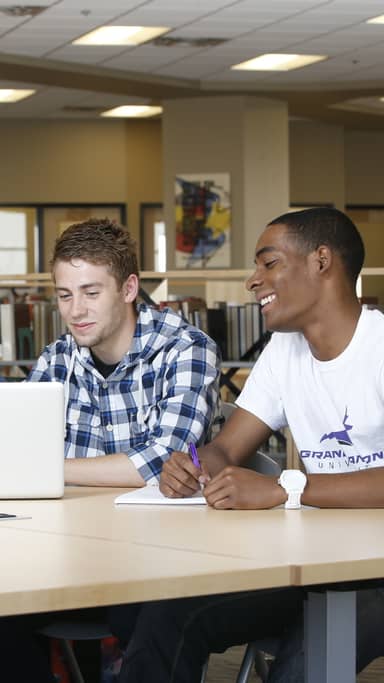 Group of GCU campus students review latest tuition fees on a laptop