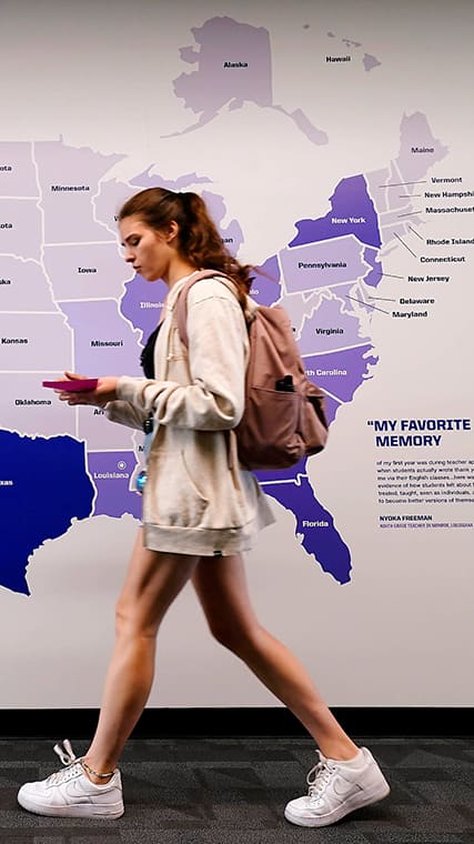 girl walking in front of mural