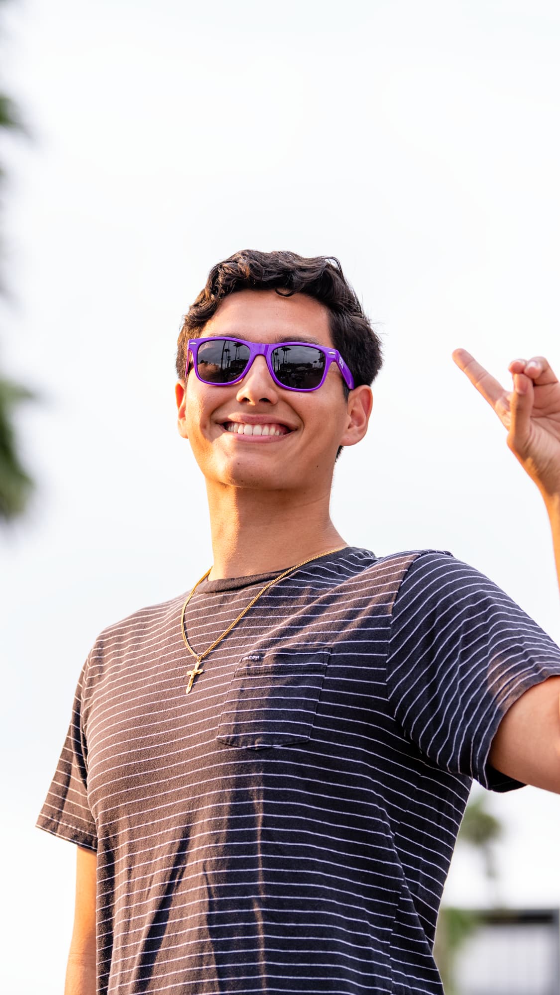 Student showing "lopes up" hand gesture while on campus