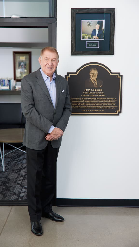 Jerry Colangelo posing by a Colangelo College of Business plaque