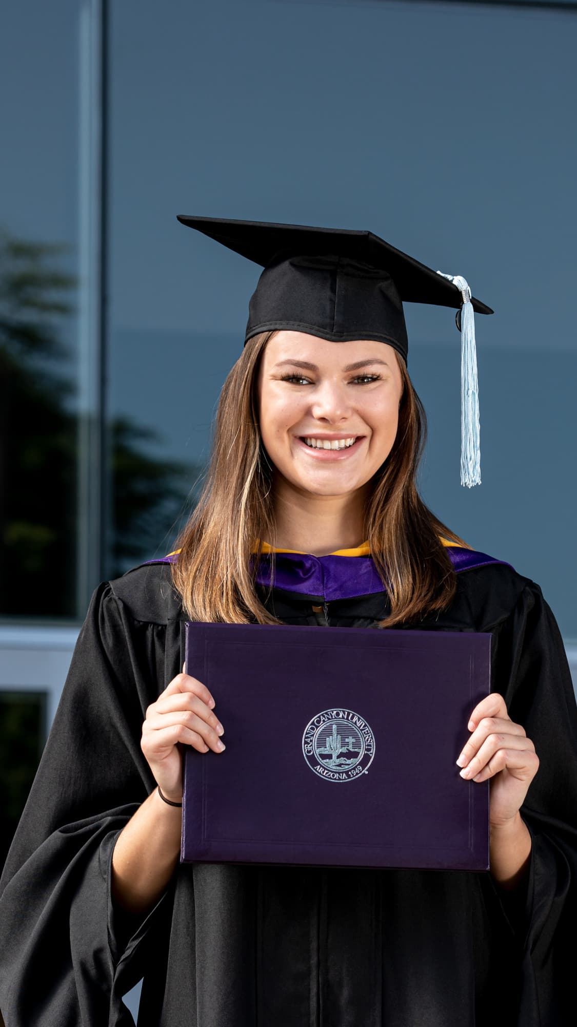 Female GCU bachelor's degree graduate standing outside after graduation