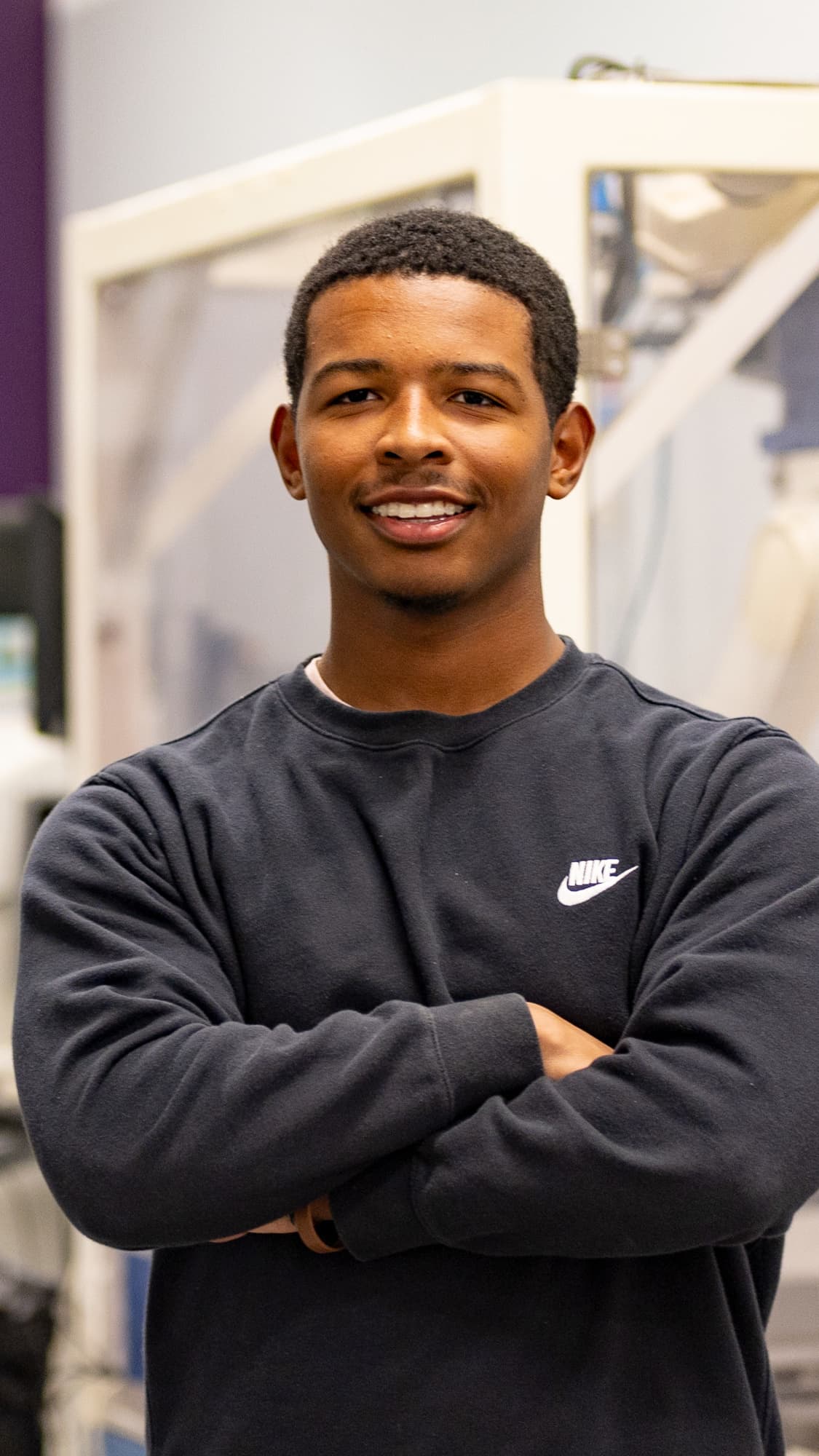 Smiling male technology degree student standing in GCU lab on campus