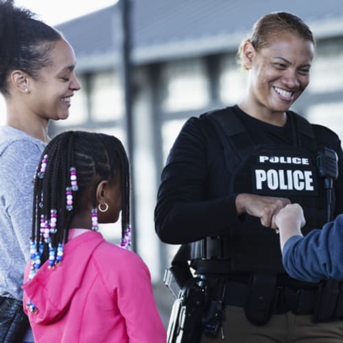 Police officer bumps fists with an 11-year-old.