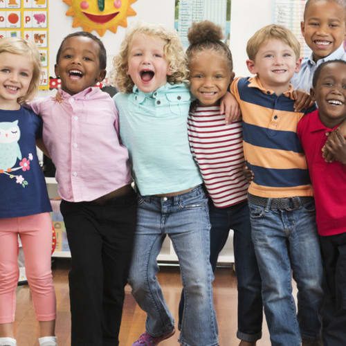 Happy kids gathered together in a classroom.