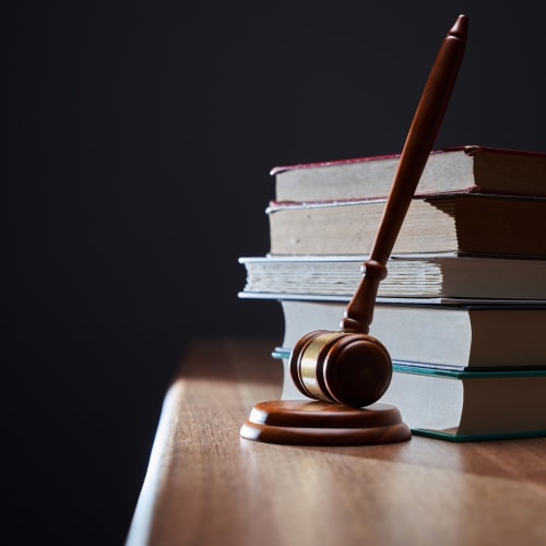 Gavel resting against book stack.
