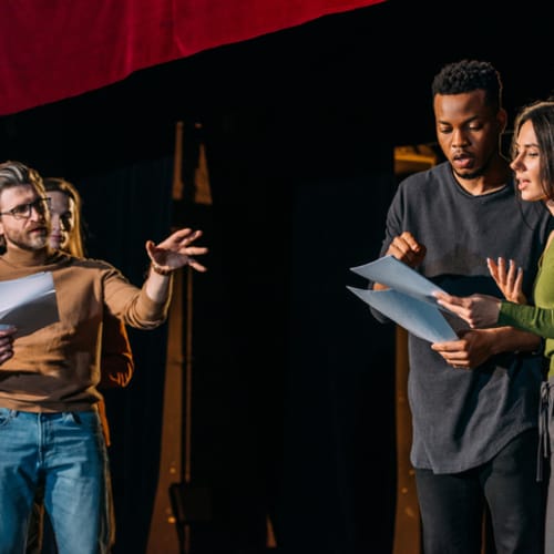  Theater director, multicultural actors and actress rehearsing on stage - stock photo