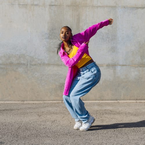 Woman breakdancing in front of wall - stock photo