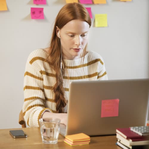 Female editor sitting at a desk with her laptop and notes