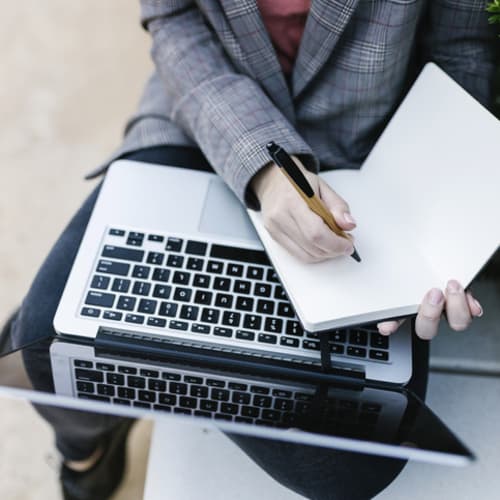 Journalist with a laptop and notepad out