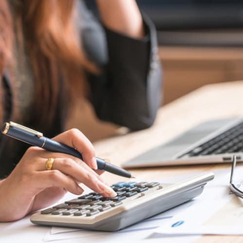 woman's using a calculator and working on laptop