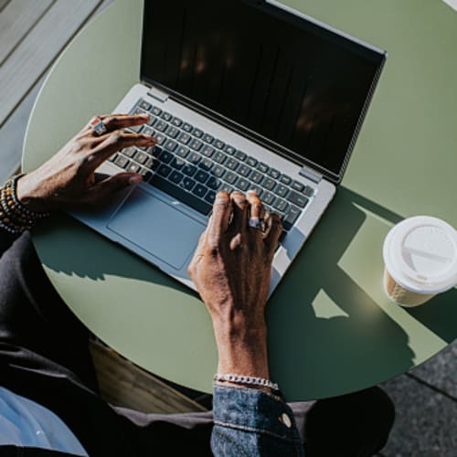 Man working on computer with coffee