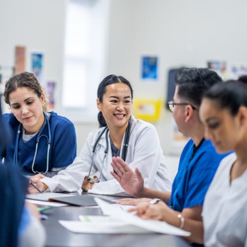 Team of nurses sitting at a table talking