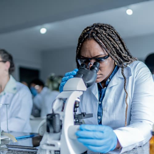 girl in class looking in microscope