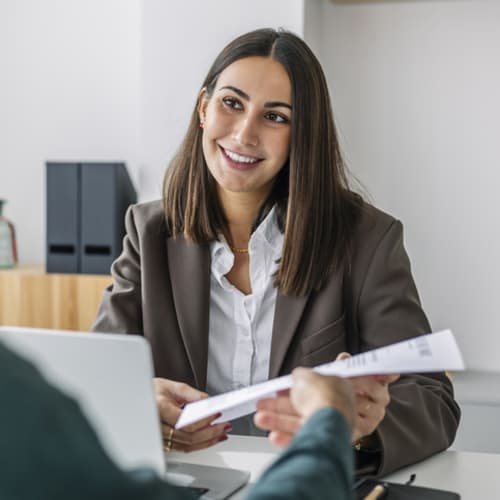 interviewee handing interviewer paper resume