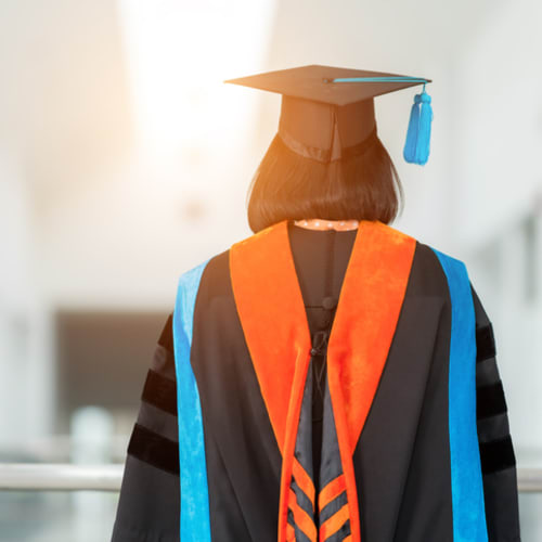 PhD student in cap and gown for graduation