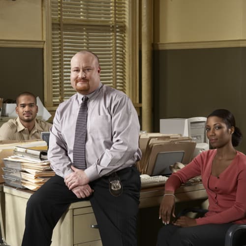 three homicide detectives facing the camera