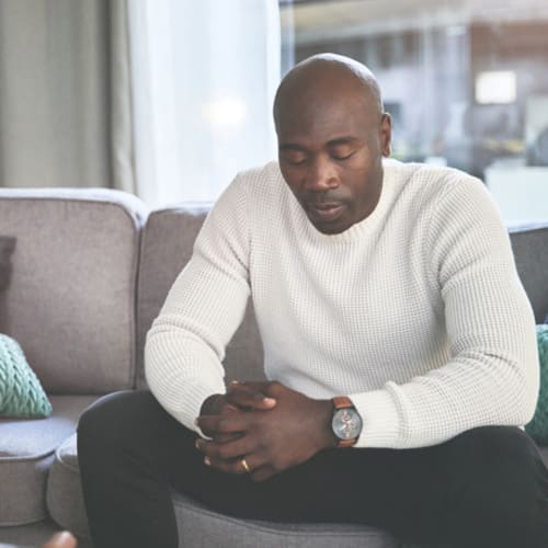 Man sitting on a couch talking with a grief counselor