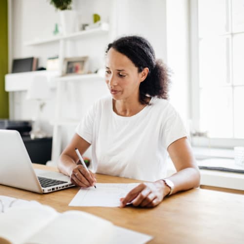 Female doctoral student working towards her online PhD on a laptop