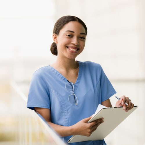 Female nursing student holding clipboard in lab room