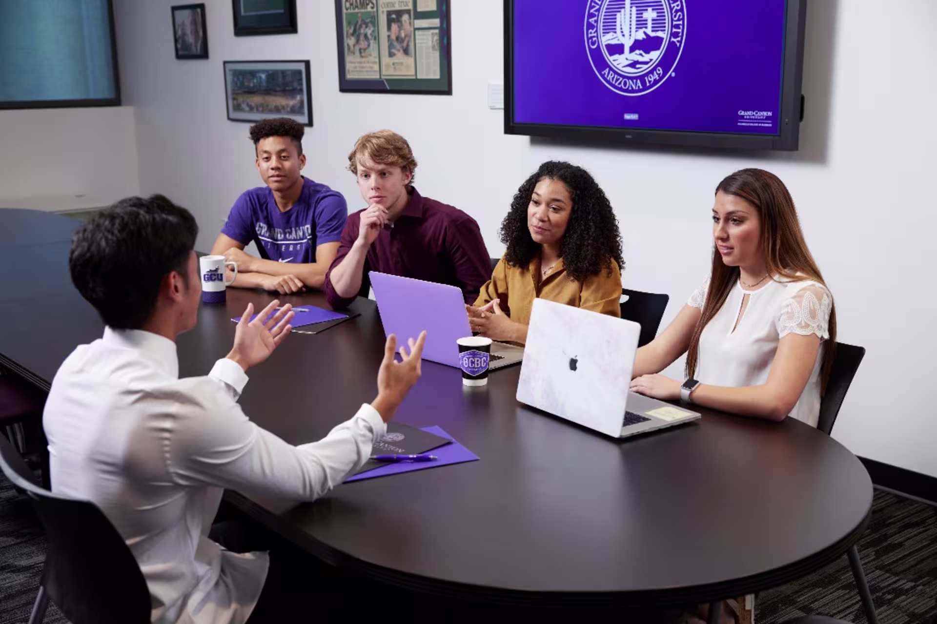 Entrepreneurship students sitting in board room and presenting projects