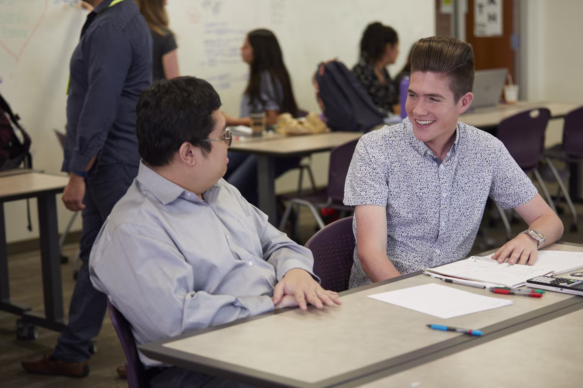 GCU Math teacher talking with student sitting at desk