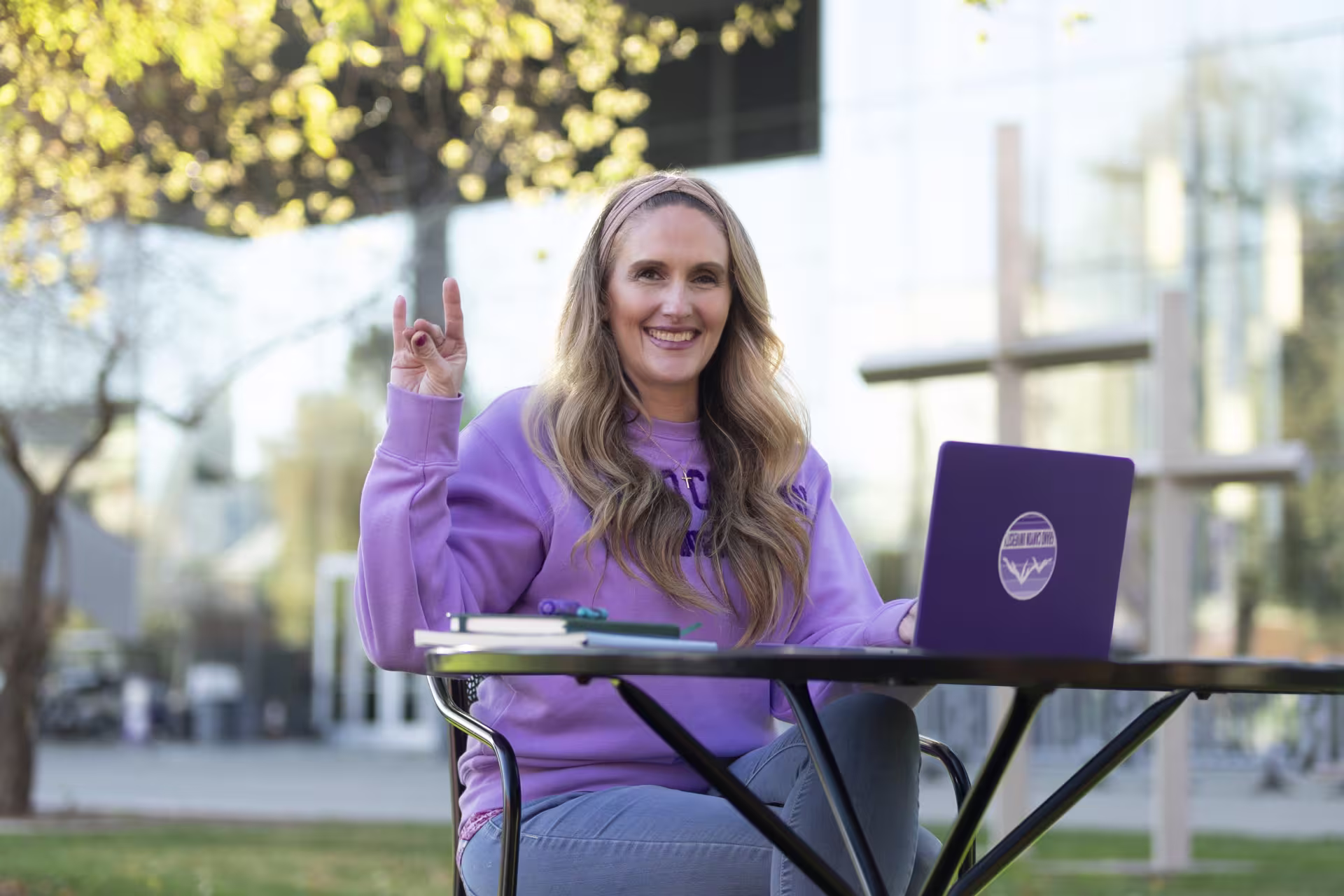 Female online certificate student working on laptop outside