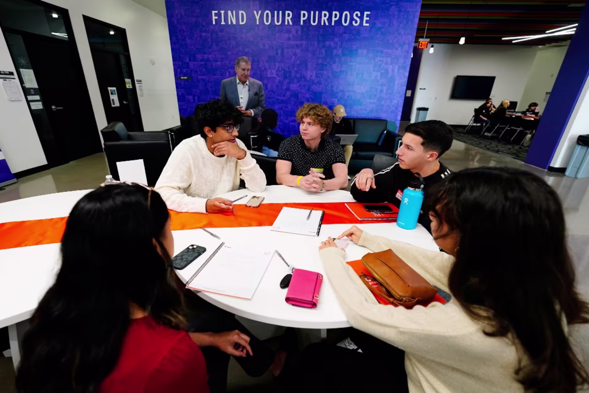 High school students sitting around table in school setting