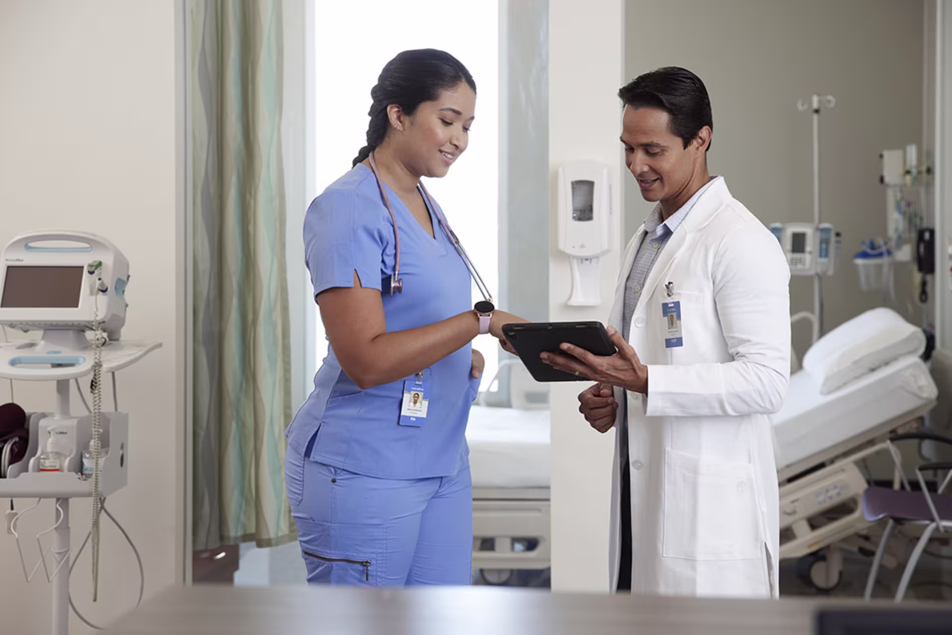 Male and female nurses examining results on tablet